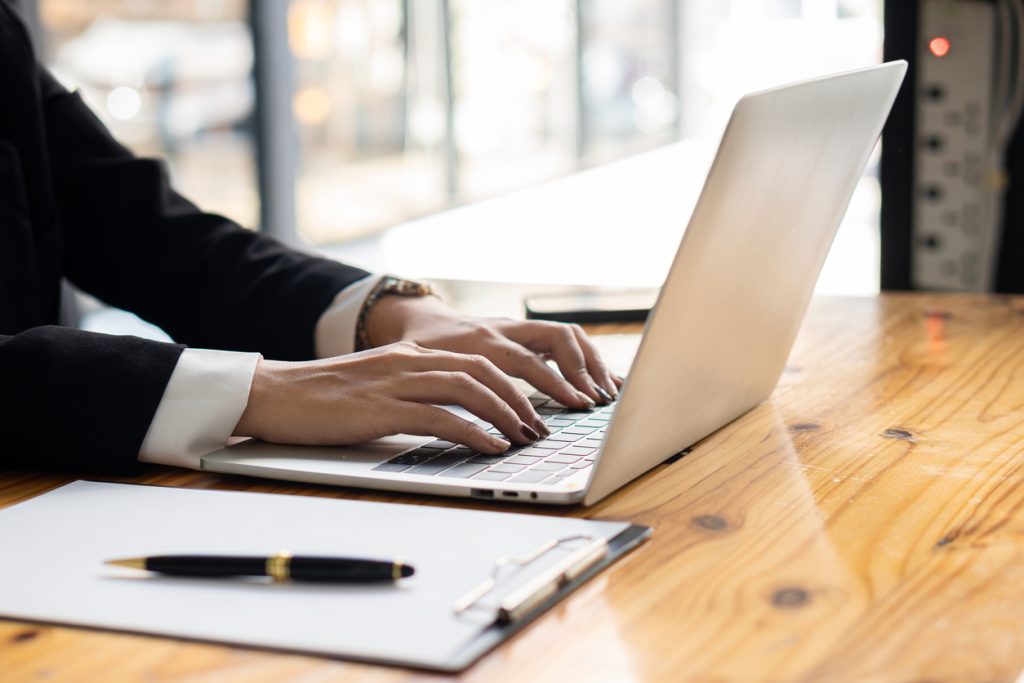 Young Asian businessman working with laptop, checking graphs, company budget reports, production control. Operational inspection cost plus price Close up pictures